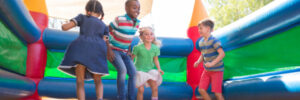 Kids enjoying a colorful bounce house at a birthday party.